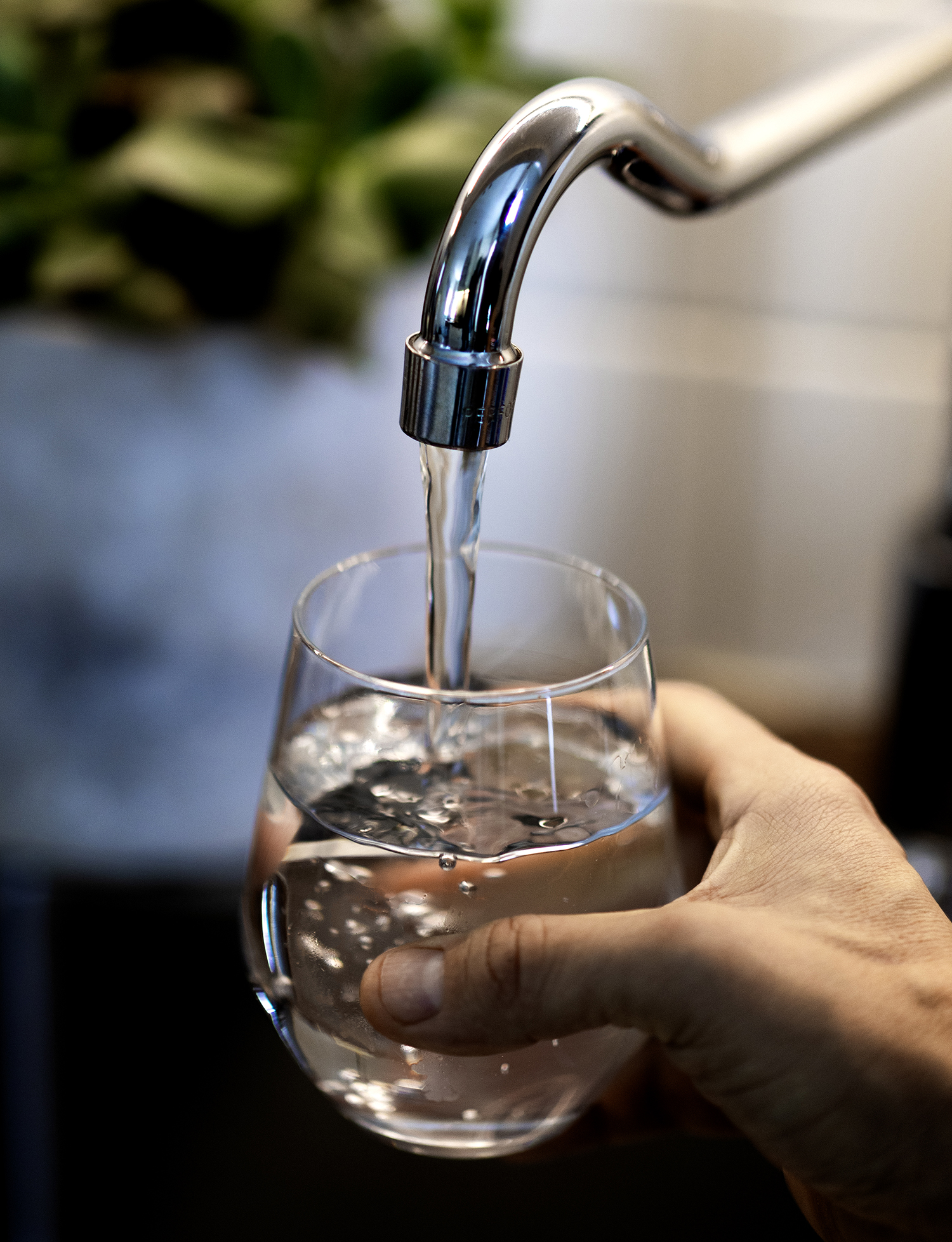 Vattenkran, glas och hand